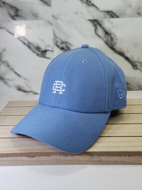 Reigning Champ New Era Sky Blue Baseball Cap with White Monogram. RC.